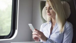 Una giovane donna d'affari usa il telefonino durante un viaggio
