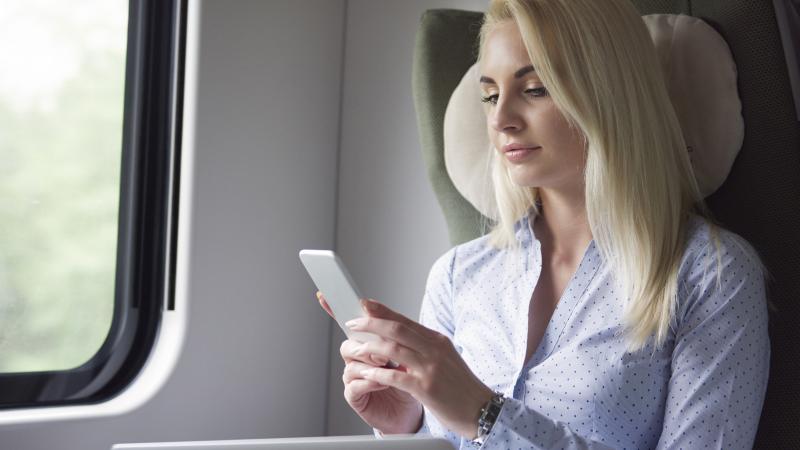 Una giovane donna d'affari usa il telefonino durante un viaggio